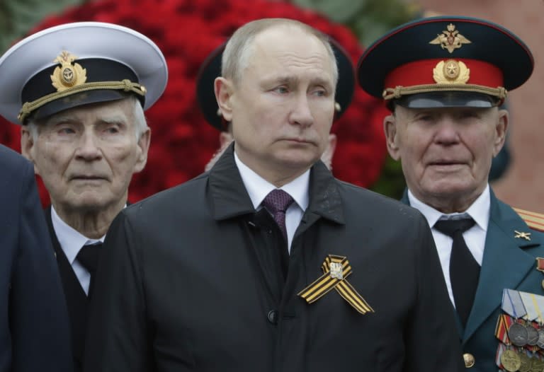Le président russe Vladimir Poutine entouré par des vétérans lors de la parade annuelle du jour de la victoire sur l'Allemagne nazie, le 9 mai 2021 à Moscou