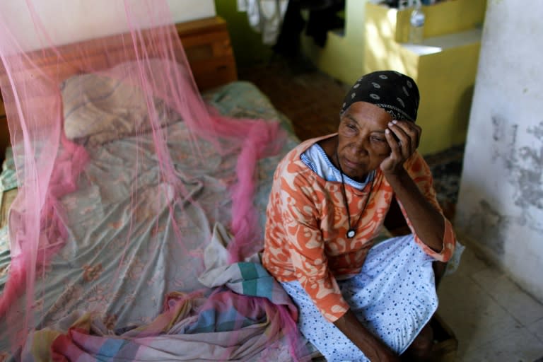 Aurea Cruz, 66, sits on her bed inside her house damaged by Hurricane Maria in Vieques, Puerto Rico