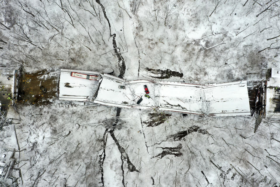 Vehicles rest on a bridge following its collapse, in Pittsburgh, Pa. on Jan. 28. The bridge spanning a ravine collapsed, requiring rescuers to rappel nearly 150 feet, while others formed a human chain to help rescue multiple people from a dangling bus.<span class="copyright">Gene J. Puskar—AP</span>