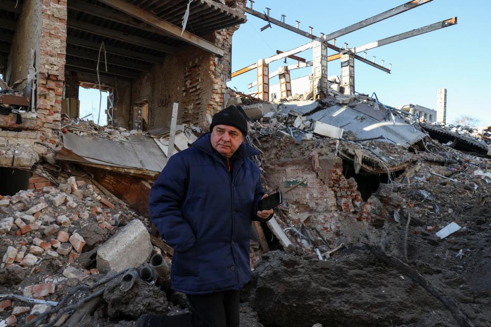 A local resident stands next to a building destroyed by a Russian missile strike, amid Russia's attack of Ukraine, in Kharkiv (REUTERS)