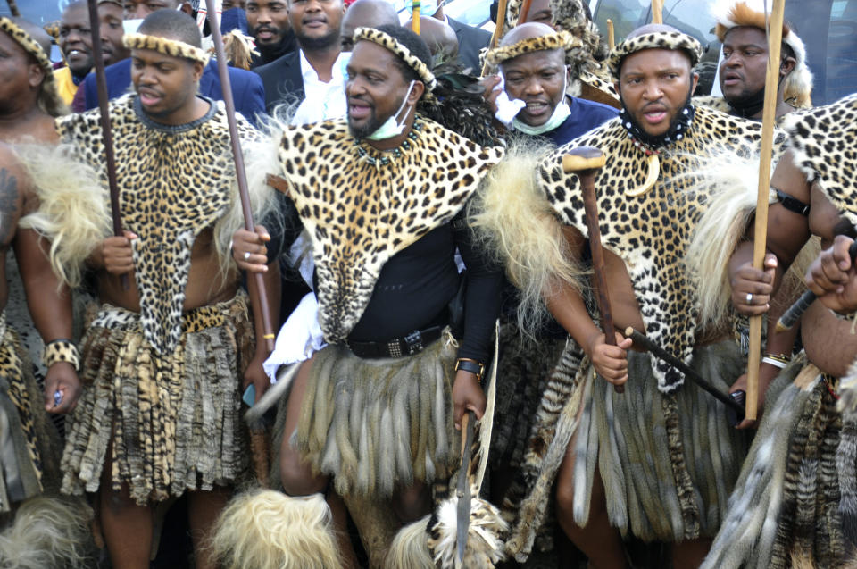 Prince Misuzulu Zulu, centre, flanked by fellow warriors in traditional dress at the KwaKhangelamankengane Royal Palace, during a ceremony, in Nongoma, Friday May 7, 2021. A new Zulu king in South Africa has been named amid scenes of chaos as other members of the royal family questioned Prince Misuzulu Zulu’s claim to the title. He was suddenly whisked away from the public announcement at a palace by bodyguards. The controversy over the next king has arisen after the death in March of King Goodwill Zwelithini, who had reigned since 1968. Zwelithini apparently named one of his six wives, Queen Mantfombi Shiyiwe Dlamini Zulu, as the “regent of the Zulu kingdom” in his will. But her death just over a week ago after holding the title for only a month has thrown the royal succession into turmoil. (AP Photo)