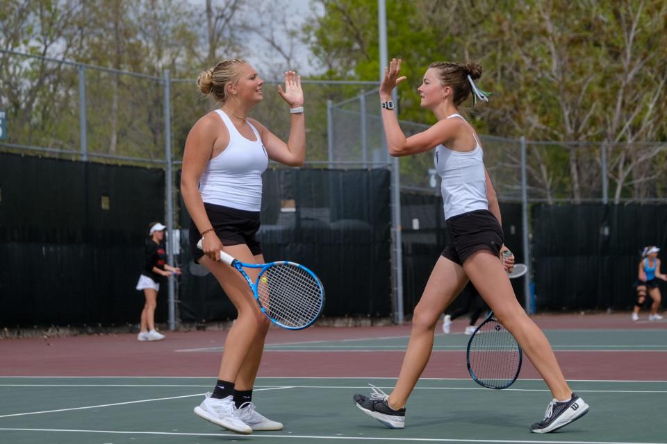 Fossil Ridge’s Afton Sidwell, left, and Abby Seager high-five after winning a point in a quarterfinal doubles match against Rocky Mountain’s Nora and Lucia Johnson during day one of the Colorado 5A girls state tennis tournament at City Park in Denver, Colo., on Thursday, May 9, 2024.