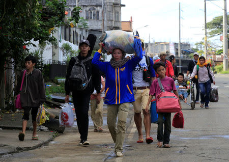 Evacuees with their belongings walk along a main street of Marawi city, after government troops' continuous assault with insurgents from the so-called Maute group, who has taken over large parts of the city, in Marawi City, southern Philippines May 27, 2017. REUTERS/Romeo Ranoco