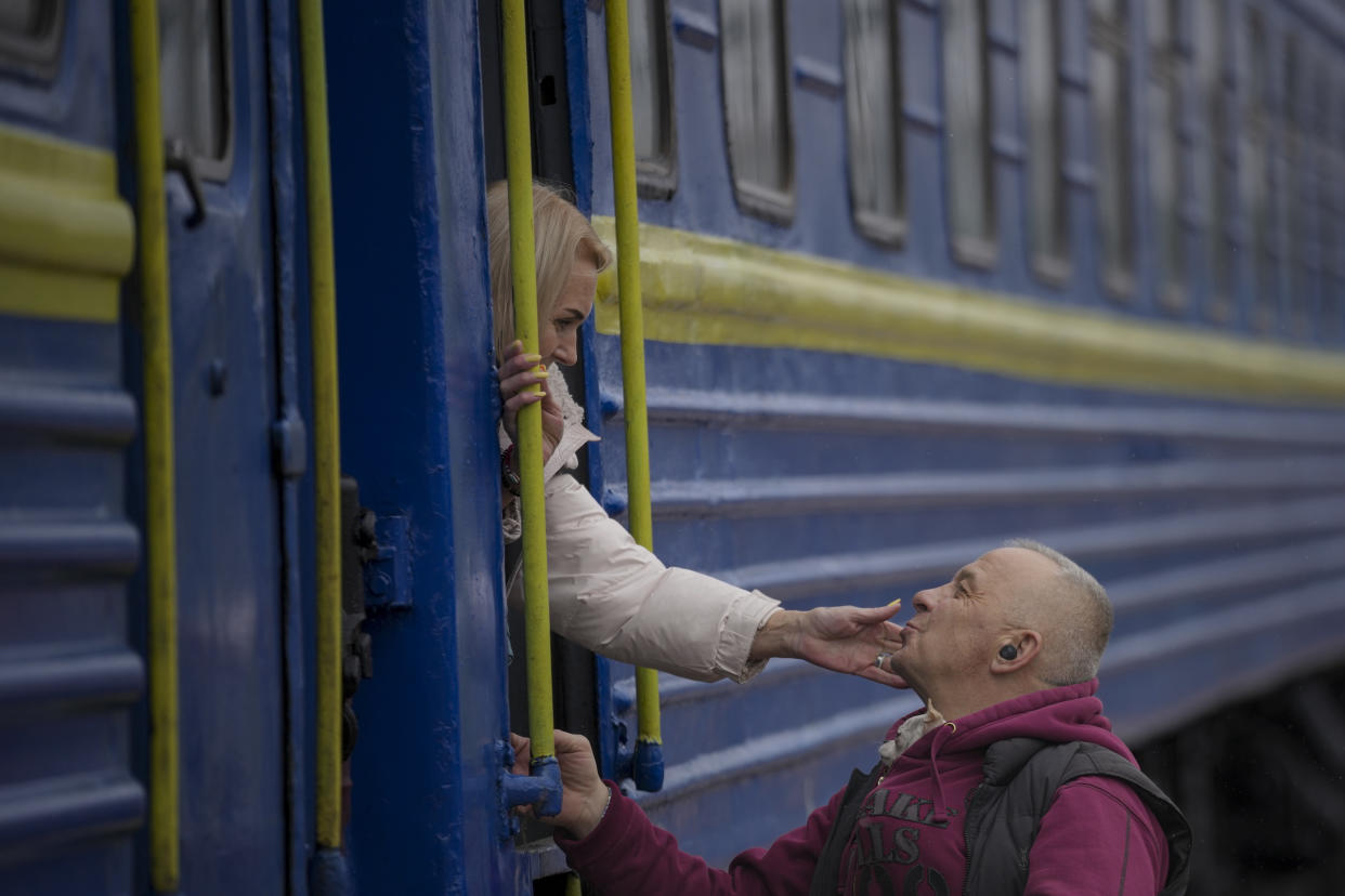 A man kisses a woman's hand as she boards a train in Kyiv, on Thursday.