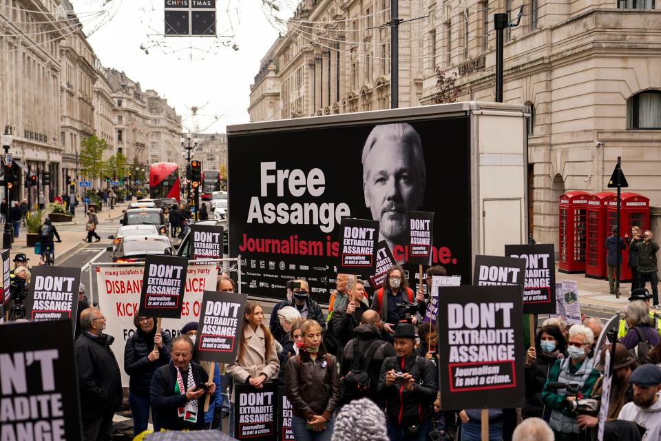Supporters of WikiLeaks founder Julian Assange hold placards and take part in a march in London, Saturday, Oct. 23, 2021, ahead of next week's extradition case appeal.