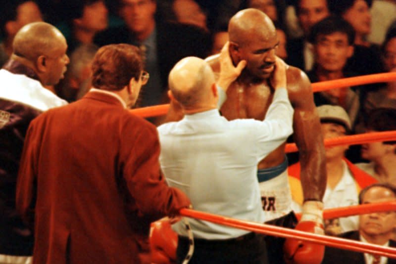 Veteran referee Mills Lane inspects the right ear of defending heavyweight champion Evander Holyfield after challenger Mike Tyson bit it in Round 3 of their title fight on June 28, 1997, at the MGM Grand in Las Vegas. Tyson was disqualified moments later after biting Holyfield's left ear. File Photo by Jim Ruymen/UPI