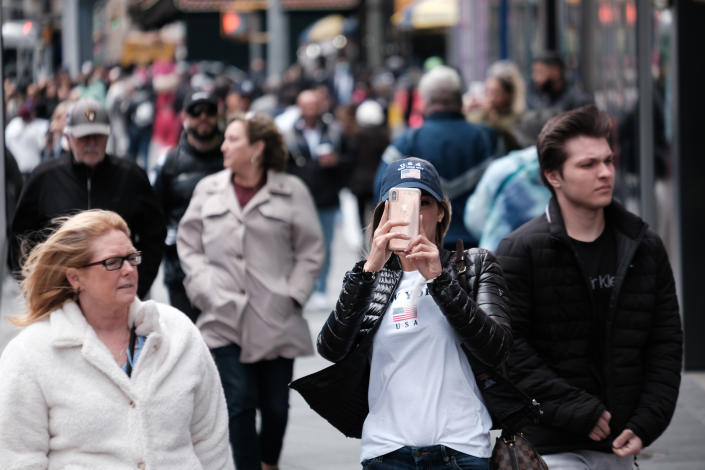 People walk through Times Square in New York City. 