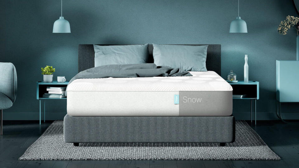  Casper Snow mattress review: Image shows the Casper Snow mattress placed on a light grey bed frame in a blue and green bedroom. 