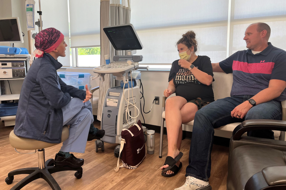 Obstetrician Taylar Swartz visits with patient Addie Comegys and her husband, Jeff Comegys. As she neared her due date, Addie Comegys would need to make the trip weekly for checkups at the hospital, which is bucking a national trend by maintaining labor and delivery services.