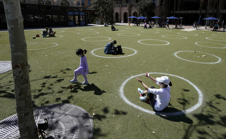 Visitors to the Pearl Brewery use circles marked for social distancing to help battle the COVID-19 virus, Wednesday, March 3, 2021, in San Antonio. Gov. Greg Abbott says Texas is lifting a mask mandate and lifting business capacity limits next week. (AP Photo/Eric Gay)