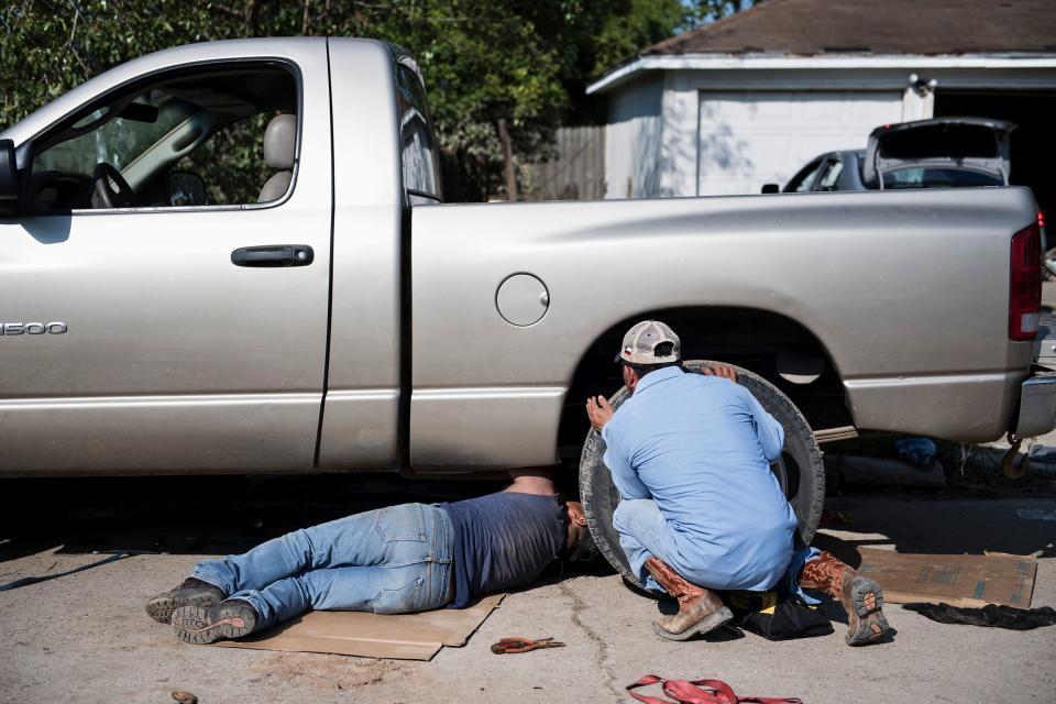 People try to&nbsp;repair a truck that was submerged in floodwater.