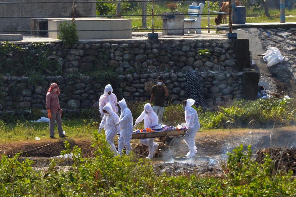 Family members and relatives wearing protective gear carry the body of their loved one who died due to the Covid-19 coronavirus at a crematorium on the outskirts of Siliguri on May 8, 2021, as India recorded more than 4,000 coronavirus deaths in a day for the first time. / Credit: DIPTENDU DUTTA/AFP via Getty Images