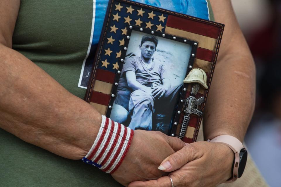 A sister of Jose Cortez, who was killed in Vietnam in 1968, holds a photo of him at a Memorial Day ceremony on Monday, May 30, 2022 at Sherrill Park.