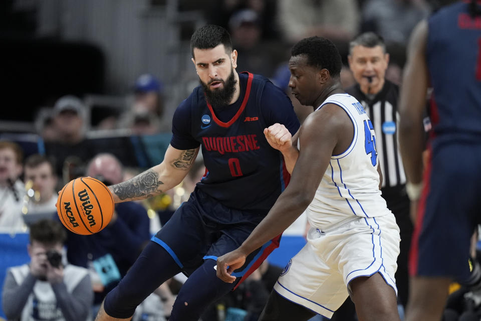 Duquesne forward Dusan Mahorcic (0) drives on BYU forward Fousseyni Traore (45) in the first half of a first-round college basketball game in the NCAA Tournament, Thursday, March 21, 2024, in Omaha, Neb. (AP Photo/Charlie Neibergall)