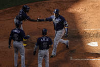 Tampa Bay Rays' Nelson Cruz, right, is congratulated after crossing the plate by Randy Arozarena, top left, Wander Franco (5) and Taylor Walls (6) after clearing the bases on two errors on the play by the Boston Red Sox during the fourth inning of a baseball game Monday, Sept. 6, 2021, at Fenway Park in Boston. (AP Photo/Winslow Townson)