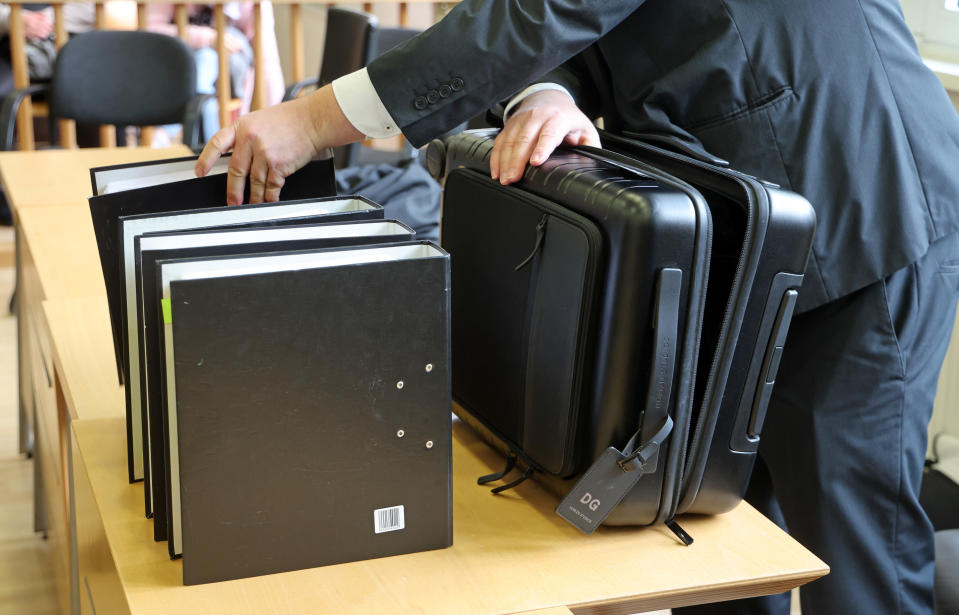 Ein Verteidiger packt im Saal des Landgerichts vor Beginn des Prozesses seine Akten aus (Bild: Bernd Wüstneck/dpa)