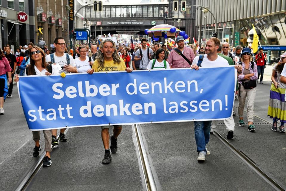 Teilnehmer gehen durch die Freidrichstraße bei einer Demonstration gegen die Corona-Maßnahmen mit einem Banner "Selber denken, statt denken lassen!".<span class="copyright">Bernd von Jutrczenka / dpa</span>