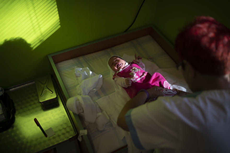 In this Nov. 16, 2018, photo, a nurse dresses a baby at the Kezmarok hospital in Kezmarok, Slovakia. An investigation by The Associated Press has found that women and their newborns in Slovakia are routinely, unjustifiably and illegally detained in hospitals across the European Union country. (AP Photo/Felipe Dana)