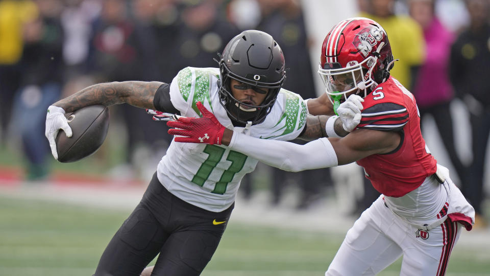 Utah cornerback Zemaiah Vaughn (5) tackles Oregon wide receiver Troy Franklin (11) during the first half of an NCAA college football game Saturday, Oct. 28, 2023, in Salt Lake City. (AP Photo/Rick Bowmer)
