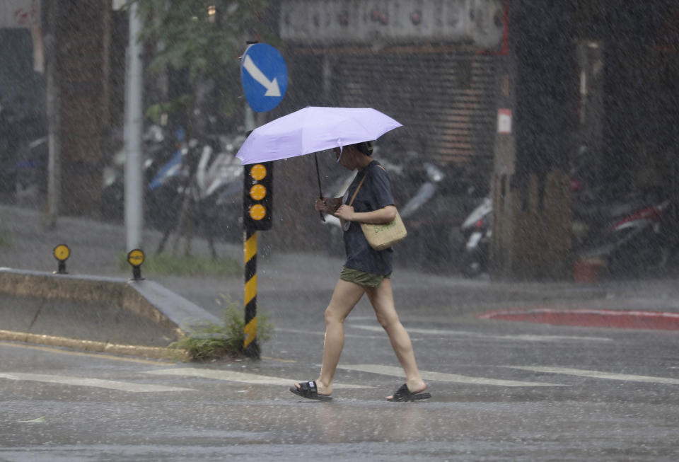 A woman walks in the rain as Typhoon Koinu approaches to Taiwan in Taipei, Taiwan, Wednesday, Oct. 4, 2023. (AP Photo/Chiang Ying-ying)