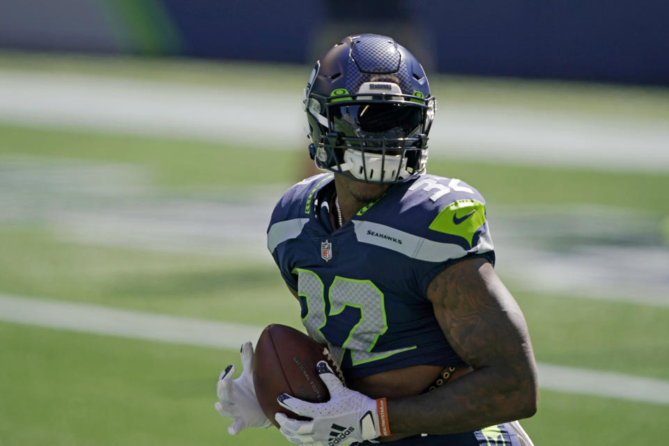 Seattle Seahawks running back Chris Carson holds the football as players warm up for an NFL football scrimmage Wednesday, Aug. 26, 2020, in Seattle. (AP Photo/Ted S. Warren)