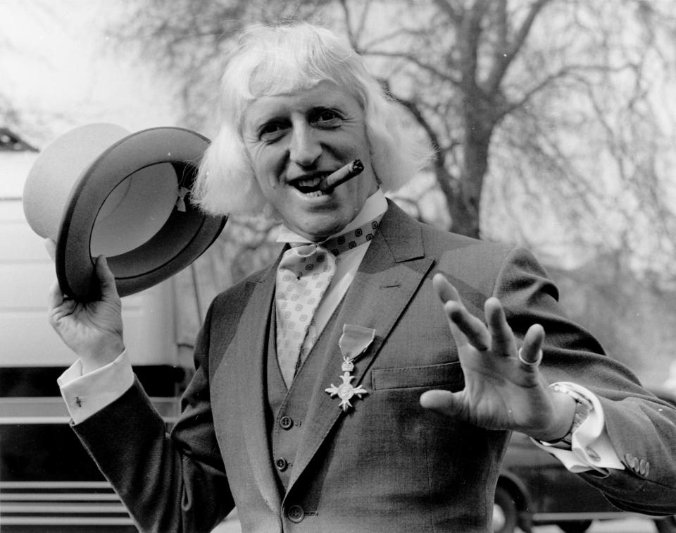 Jimmy Savile sporting his OBE after his investiture at Buckingham Palace, London