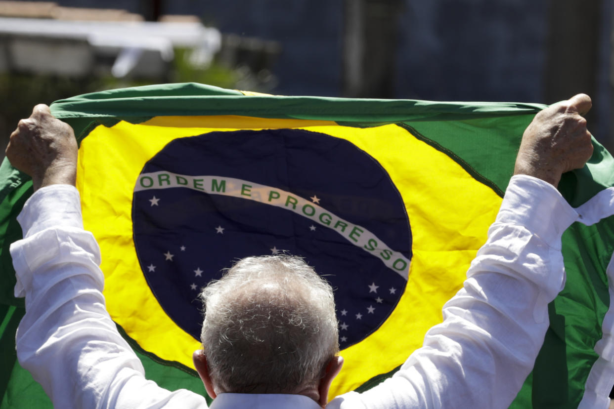 Former Brazilian President Luiz Inacio Lula da Silva, who is running for president again, holds a Brazilian flag after voting in a presidential run-off election in Sao Paulo, Brazil, Sunday, Oct. 30, 2022.(AP Photo/Marcelo Chello)