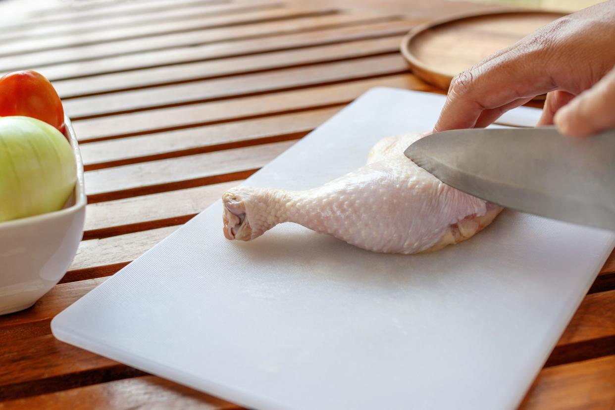 Chef cutting chicken for cooking