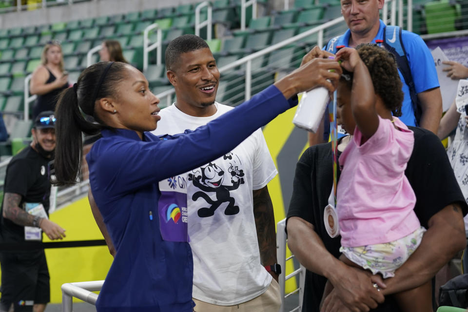 Allyson Felix, of the United States, gives her daughter Camryn her bronze medal after the 4x400-meter mixed relay final at the World Athletics Championships Friday, July 15, 2022, in Eugene, Ore. (AP Photo/Charlie Riedel)