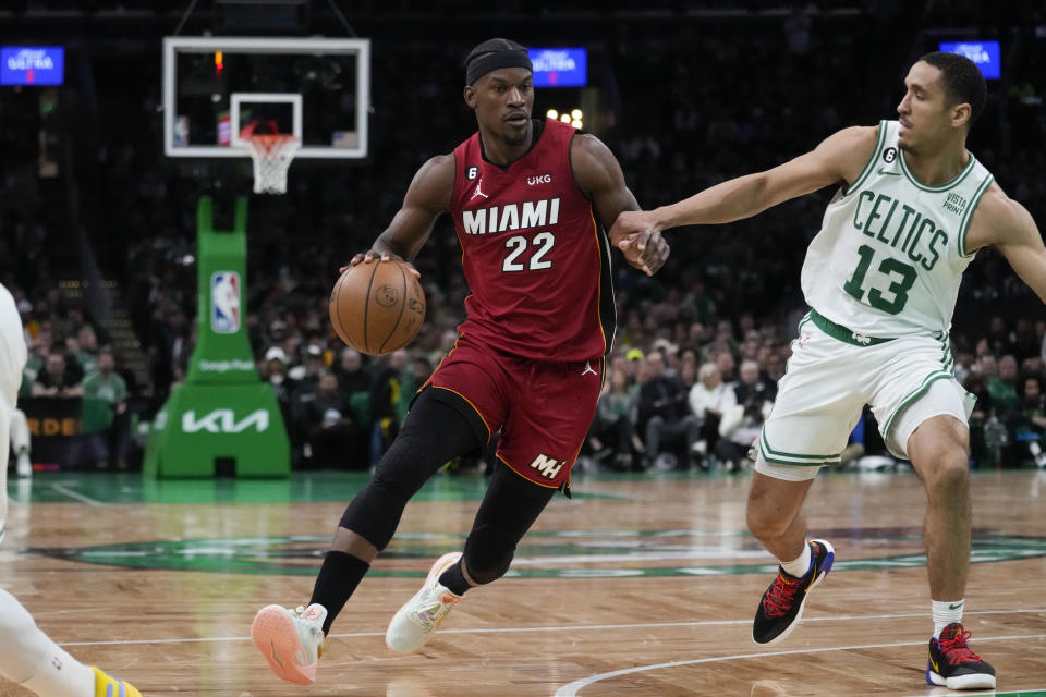 Miami Heat forward Jimmy Butler (22) drives to the basket against Boston Celtics guard Malcolm Brogdon (13) in the first half of Game 1 of the NBA basketball Eastern Conference finals playoff series in Boston, Wednesday, May 17, 2023. (AP Photo/Charles Krupa)