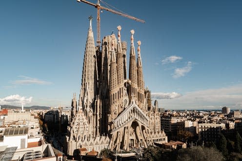 <span class="caption">The new tower stands completed, to the left, with its summit star in place.</span> <span class="attribution"><a class="link " href="https://www.shutterstock.com/image-photo/sagrada-familia-basilica-barcelona-antoni-gaudi-2101137517" rel="nofollow noopener" target="_blank" data-ylk="slk:Petr Tran | Shutterstock;elm:context_link;itc:0;sec:content-canvas">Petr Tran | Shutterstock</a></span>