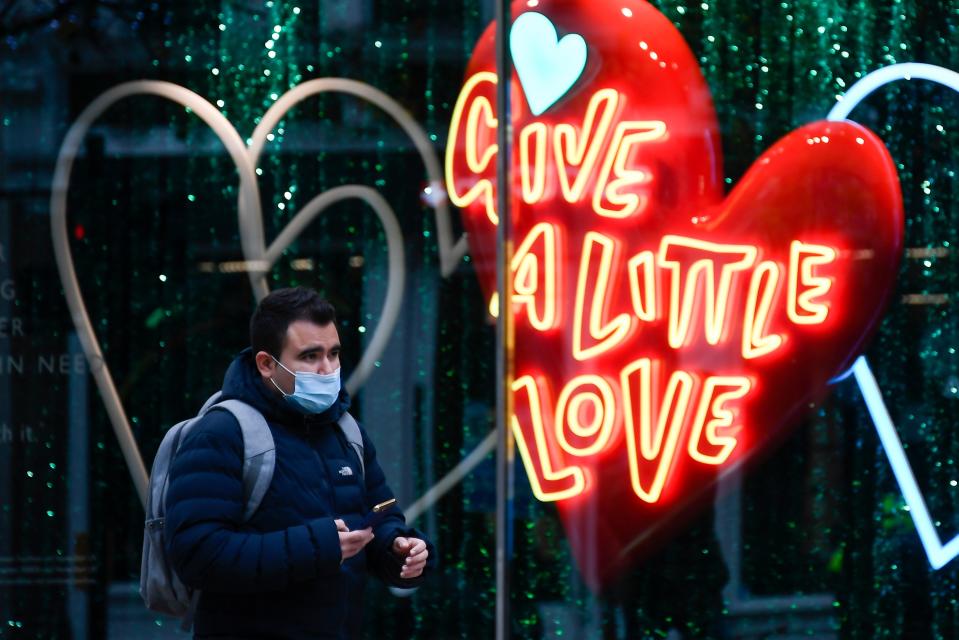 <p>Pedestrians wearing face masks due to the COVID-19 pandemic, walk past Christmas-themed window displays inside Burlington Arcade. </p> (AP)