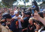 Formula One - F1 - Australian Grand Prix - Melbourne, Australia - 25/03/2017 Mercedes driver Lewis Hamilton of Britain (C) pushes back a TV cameraman in the crush as he signs autographs alongside Red Bull Racing's Australian driver Daniel Ricciardo. REUTERS/Jason Reed