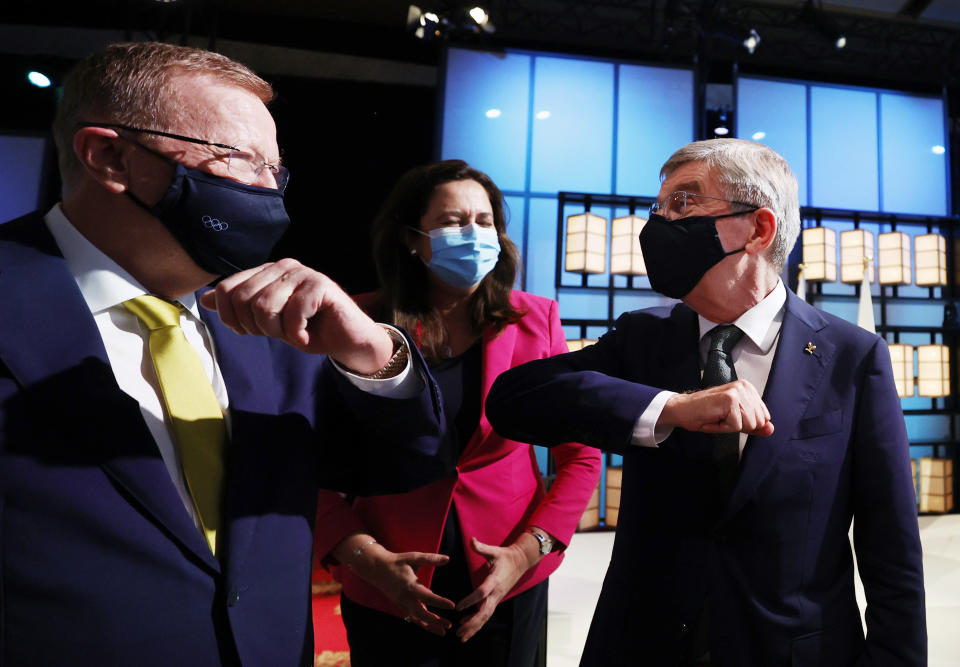 President of the International Olympic Committee Thomas Bach, right, bumps elbows with members of the Brisbane 2032 delegation, from left, John Coates AC, President, Australian Olympic Committee and The Honourable Annastacia Palaszczuk MP, Premier of Queensland and Minister for Trade, after Brisbane was announced as the 2032 Summer Olympics host city during the IOC Session at Hotel Okura in Tokyo, Wednesday, July 21, 2021. (Toru Hanai/Pool Photo via AP)