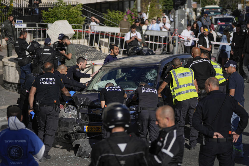 Israeli police examine the scene of a car ramming attack, in Jerusalem, Monday, April 24, 2023. Israeli Prime Minister Benjamin Netanyahu says multiple people have been attacked and wounded near a popular market in Jerusalem as Israel was set to mark its Memorial Day for fallen soldiers. Netanyahu spoke Monday moments after medics reported a suspected attack injured five people near the bustling, open-air Mahane Yehuda market. (AP Photo/Ohad Zwigenberg)