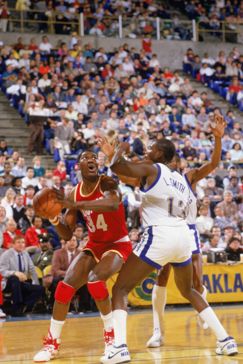 1987: Akeem Olajuwon #34 of the <a class="link " href="https://sports.yahoo.com/nba/teams/houston/" data-i13n="sec:content-canvas;subsec:anchor_text;elm:context_link" data-ylk="slk:Houston Rocket;sec:content-canvas;subsec:anchor_text;elm:context_link;itc:0">Houston Rocket</a> takes a shot against Larry Smith #13 of the Golden State Warriors during a game in the 1987-88 season. NOTE TO USER: User expressly acknowledges and agrees that, by downloading and/or using this Photograph, User is consenting to the terms and conditions of the Getty Images License Agreement. (Photo by: Otto Greule Jr/Getty Images)