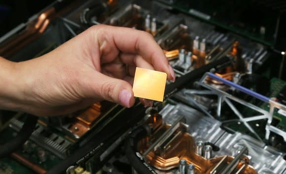 A hand holding an IBM POWER9 chip.