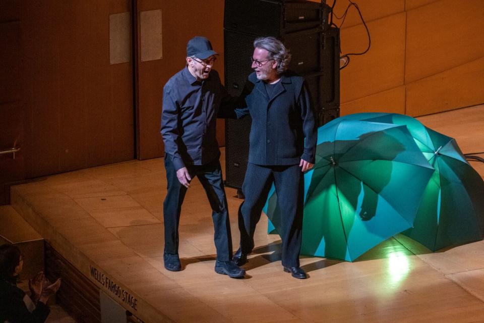 Two men appear on a stage.