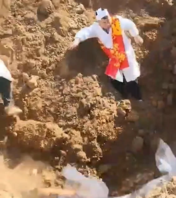 <strong>影片中可見有1名家屬在墓道上方，疑因重量加劇下方擋土牆垮塌。（圖／翻攝自微博）</strong>