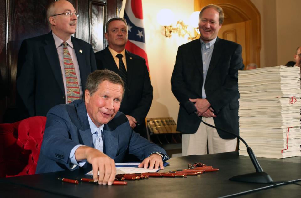 Ohio Gov. John Kasich smiles while signing the new two-year state budget during a ceremony at the Ohio Statehouse in Columbus in 2013.