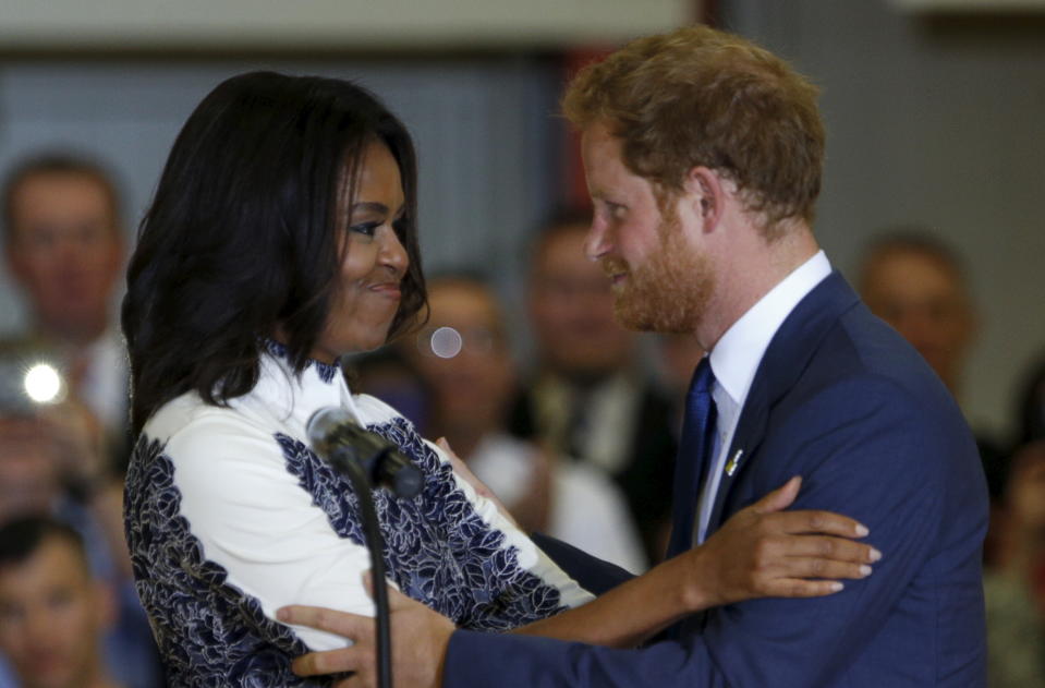 Britain's Prince Harry and first lady Michelle Obama embrace while making remarks during a visit to Fort Belvoir, Virginia October 28, 2015. Prince Harry is at Fort Belvoir to meet soldiers and spread the word about the Invictus Games, which supports wounded warriors. Prince Harry spearheaded the Invictus Games, which was first held in London last September. The next Invictus Games is planned for May in Orlando, Florida. REUTERS/Kevin Lamarque 