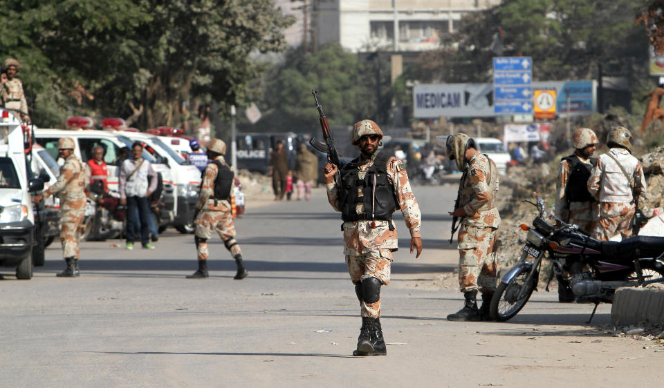 Soldiers of the Pakistani paramilitary forces cordon off the area of an attack on Wednesday, Jan. 29, 2014 in Karachi, Pakistan. Police said several members of the country's security forces have been killed in separate attacks in the southern city of Karachi. (AP Photo/Fareed Khan)