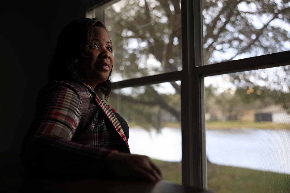 Jennifer James peers out a window at her home in Jacksonville. Once unemployed the facing homelessness, the 44-year-old single mother now has a job as a LSI travel coordinator. "Dreams do come true," she said.