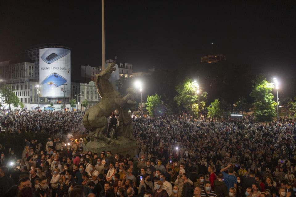 Protesters gather in front of the Serbian parliament in Belgrade, Serbia, Tuesday, July 7, 2020. Thousands of people protested the Serbian president's announcement that a lockdown will be reintroduced after the Balkan country reported its highest single-day death toll from the coronavirus Tuesday. (AP Photo/Marko Drobnjakovic)