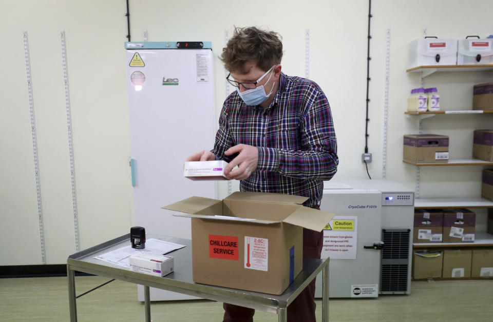 Assistant Technical Officer Lukasz Najdrowski unpacks doses of the COVID-19 vaccine developed by Oxford University and U.K.-based drugmaker AstraZeneca as they arrive at the Princess Royal Hospital in Haywards Heath, England, Saturday Jan. 2, 2021. The UK has 530,000 doses available for rollout from Monday. (Gareth Fuller/Pool via AP)