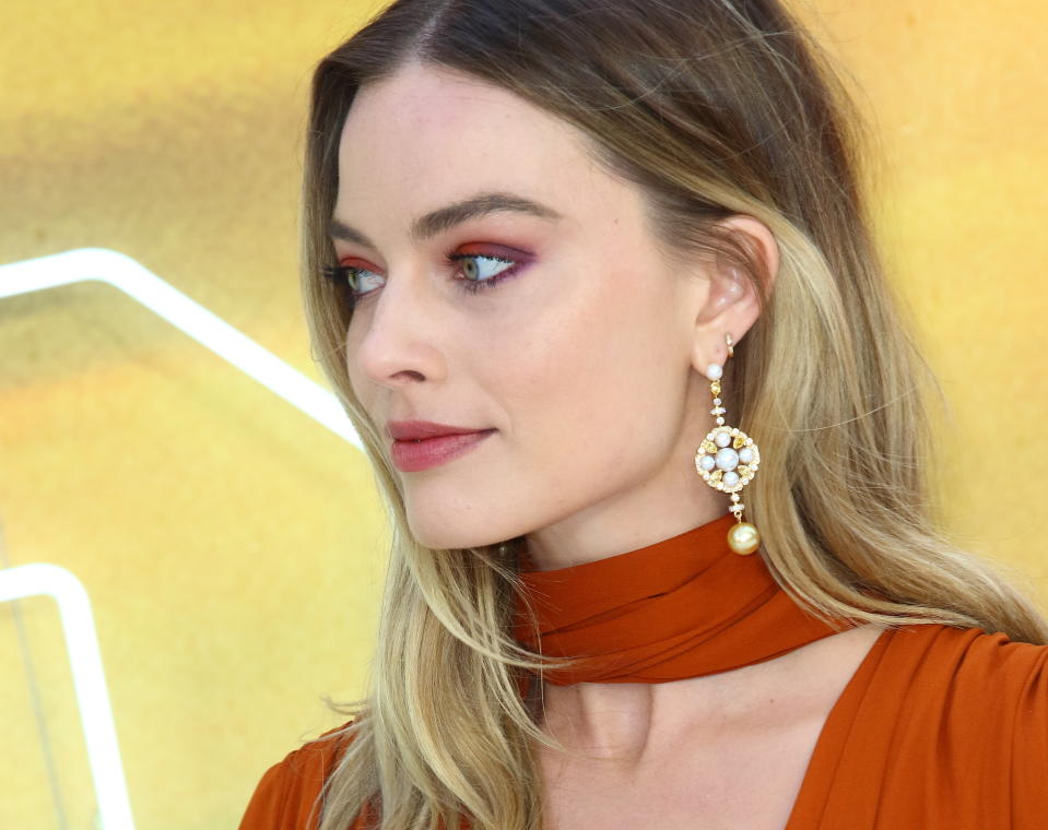 Margot Robbie matched her makeup to her sunset-hued gown [Photo via PA]