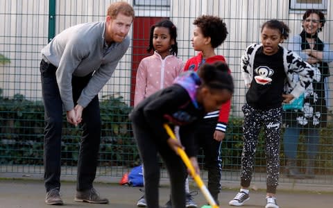 Britain's Prince Harry plays with children as he visits a Fit and Fed school holiday programme - Credit: AP Pool