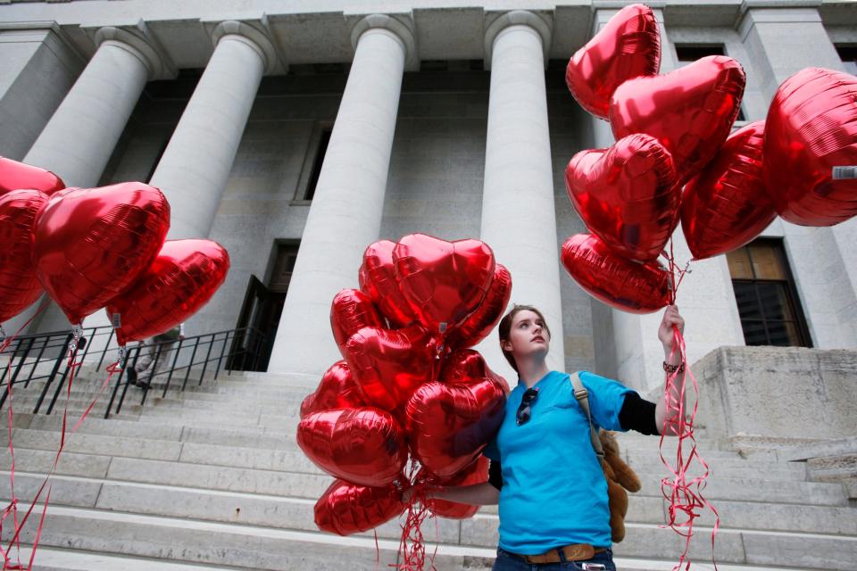 Anne Renouf helps string red heart balloons along the south side of the Ohio Statehouse in 2011 in support of the six-week abortion ban, known by supporters as the heartbeat bill.