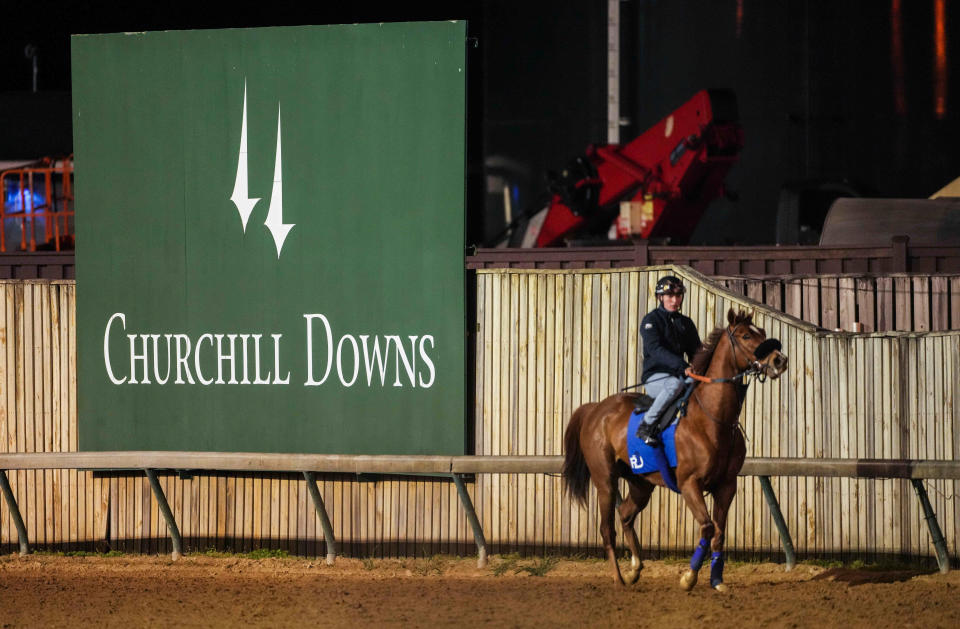 A horse and exercise rider on the track at Churchill Downs.