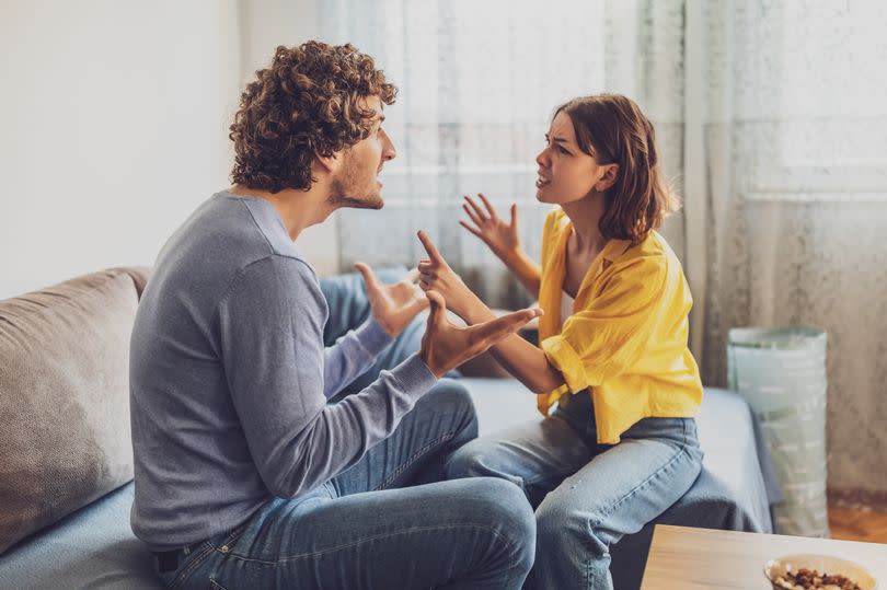 Man and woman are sitting at sofa and arguing. Relationship problems.